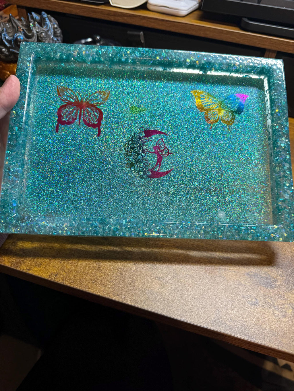 Decorative resin tray with butterfly designs on a wooden surface