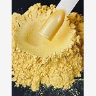 Close-up of a spoonful of yellow powder on a black background